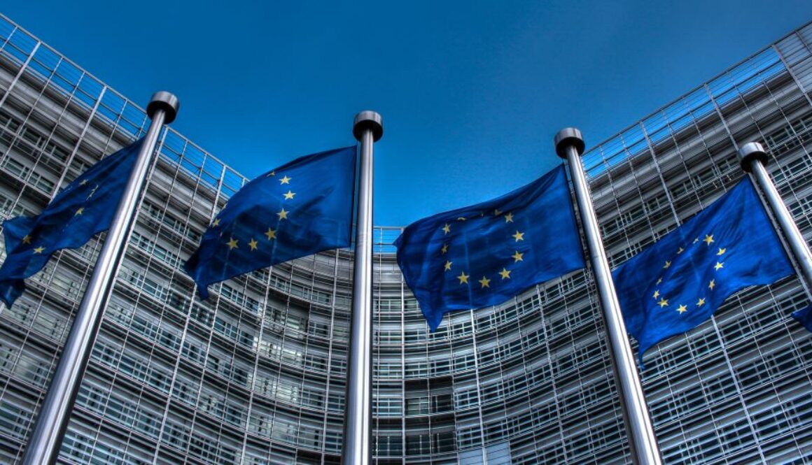 European Commission headquarters building in Brussels with EU flags.