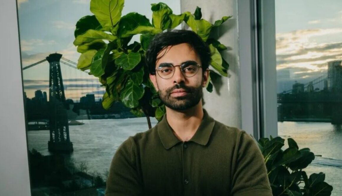 A startup founder standing in an office overlooking a river and bridge, representing a technology company focused on digital trust and cybersecurity