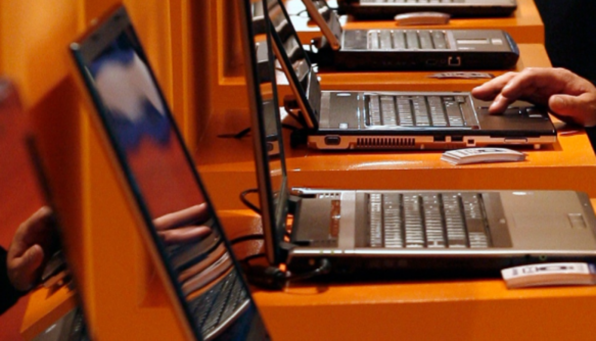 Rows of laptops in a corporate or training environment, representing enterprise AI deployment and operational systems