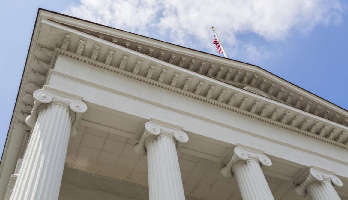 U.S. courthouse building with columns and American flag representing federal legal challenge to Colorado AI law