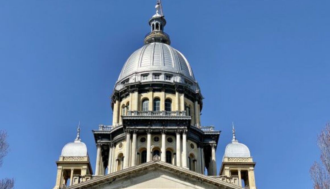 Looking up at the Illinois State Capitol dome against a clear blue sky, representing Illinois passing SB 315, the AI safety bill.
