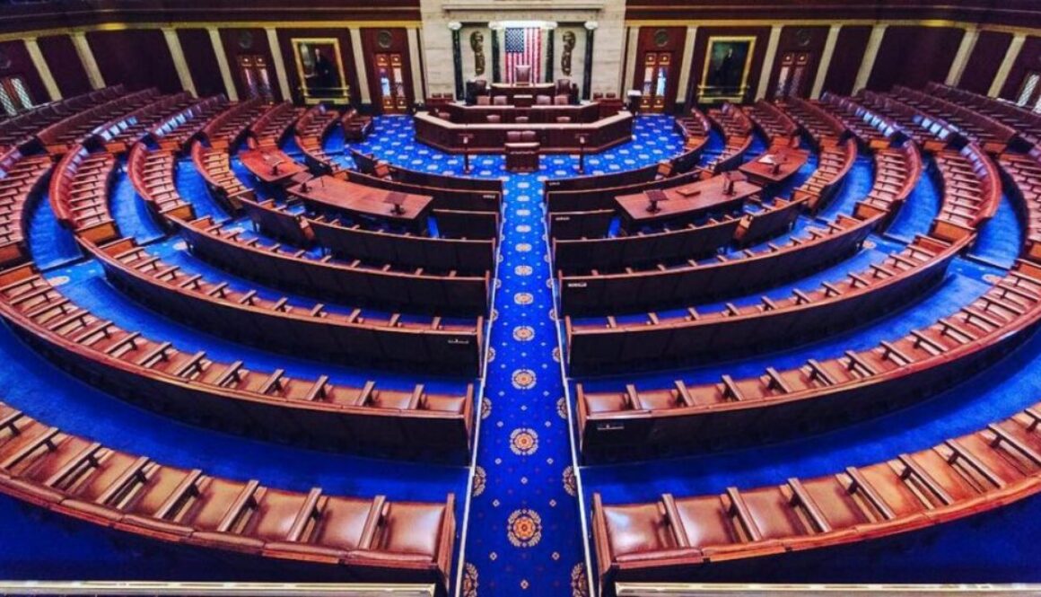 Empty U.S. House of Representatives chamber with wood desks and blue carpet, for coverage of the House passing the KIDS Act.