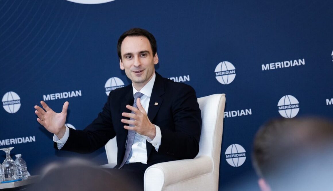 Michael Kratsios speaks beside Kellee Wicker at a 2025 Meridian event; he later rejected a new international AI regulator