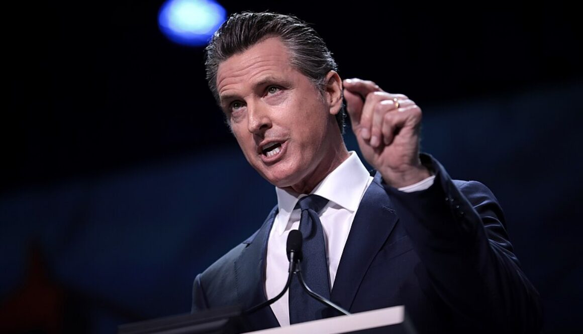 Gavin Newsom gesturing as he speaks into a podium microphone, for California's new state oversight of AI auditors