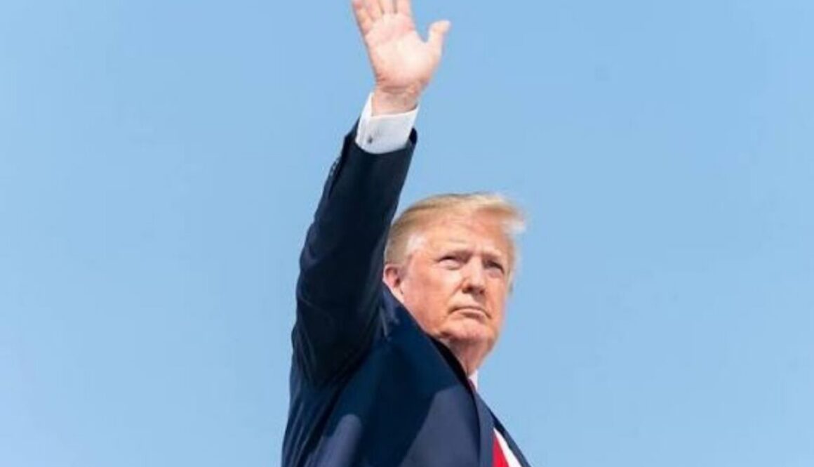 Donald Trump waving in a dark suit under a clear blue sky, on his rejection of calls to slow AI development