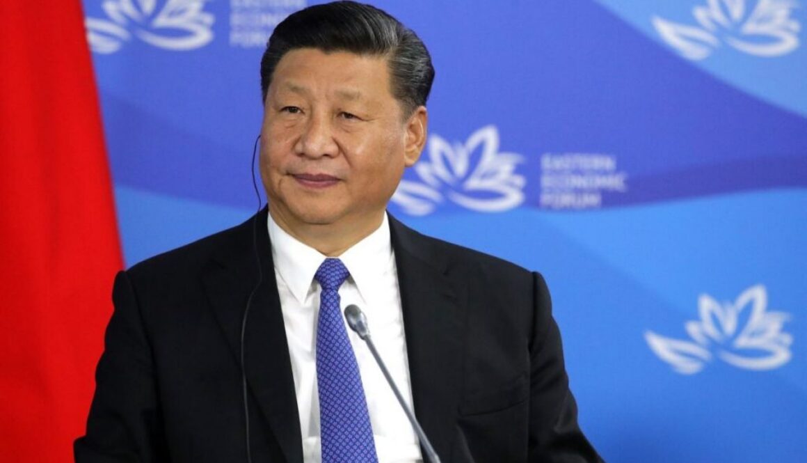 Xi Jinping at a microphone before a blue backdrop, on his call at the BRICS Summit for faster global AI rules